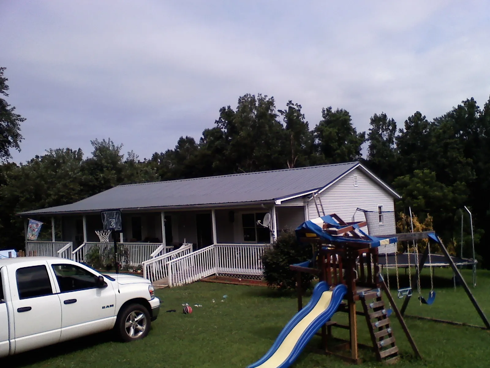 Dark metal roof on a country home with a full length front porch in Thompson